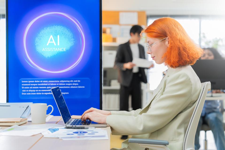 Business professional using Agentic AI assistant, in a shared office with colleagues in the background